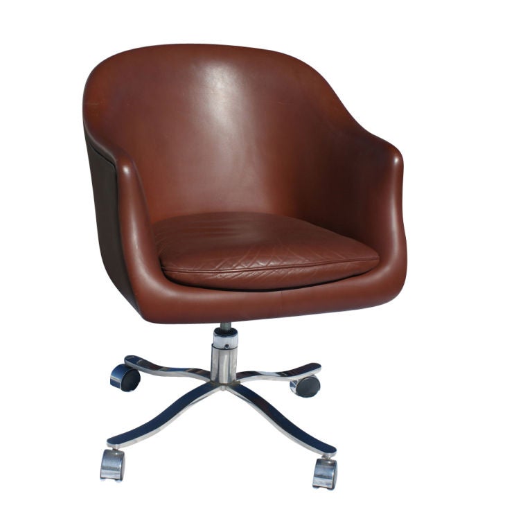 One mid century modern bucket chair designed by Nicos Zographos and made by Zographos.  Stainless steel four-star bases with casters and brown leather low back shells with a detached seat cushion.

Seat height is adjustable from 17