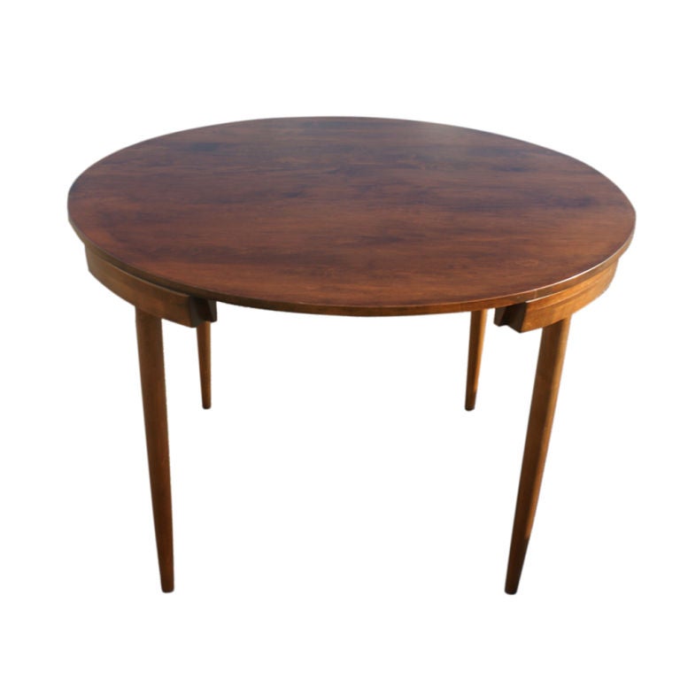 A set of mid century modern dining furniture designed by Hans Olsen and made by Winchendon.  A circular teak table with four recessed dining chairs upholstered in black leather.  The chairs measure 29