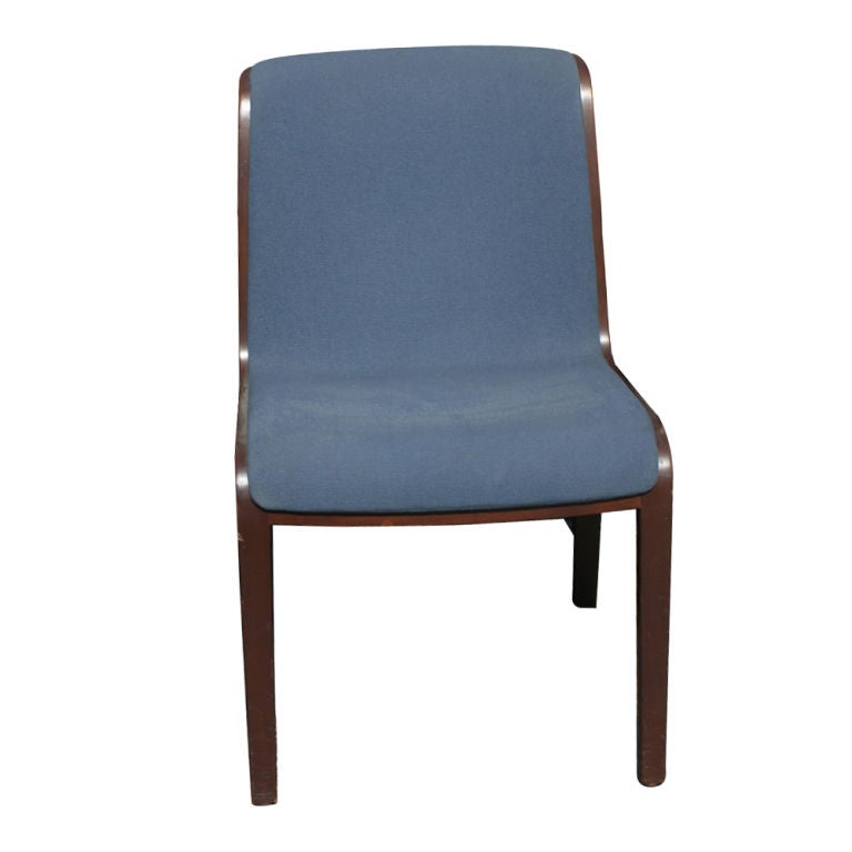A set of twelve mid century modern side or dining chairs designed by Bill Stephens and made by Knoll.  Dark stained, laminated oak frames with blue fabric upholstery.