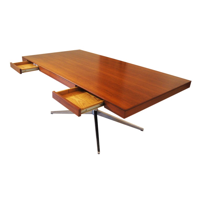 A mid century modern partners desk designed by Florence Knoll and made by Knoll. A rectangular teak top with two pencil drawers on each side and a four-star chrome base.