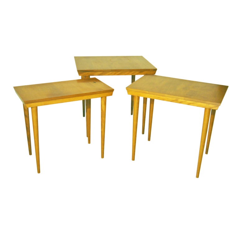 A set of three mid century modern nesting tables designed by Russel Wright and made by Conant Ball.  From the Modernmates series, the tables are solid birch.