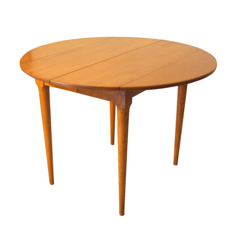 A mid century modern dop leaf dining table designed by Russel Wright and part of Conant Ball's popular Modernmates series.  The table measures 42.5