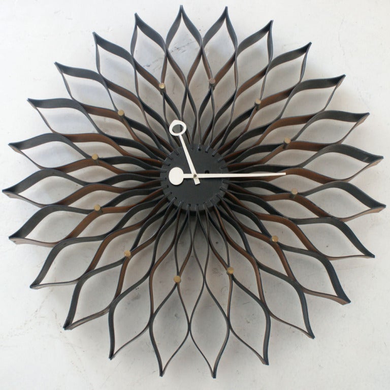 A mid century modern Sunflower clock designed by George Nelson and made by Howrad Miller.  Wood with brass accents and white hands.