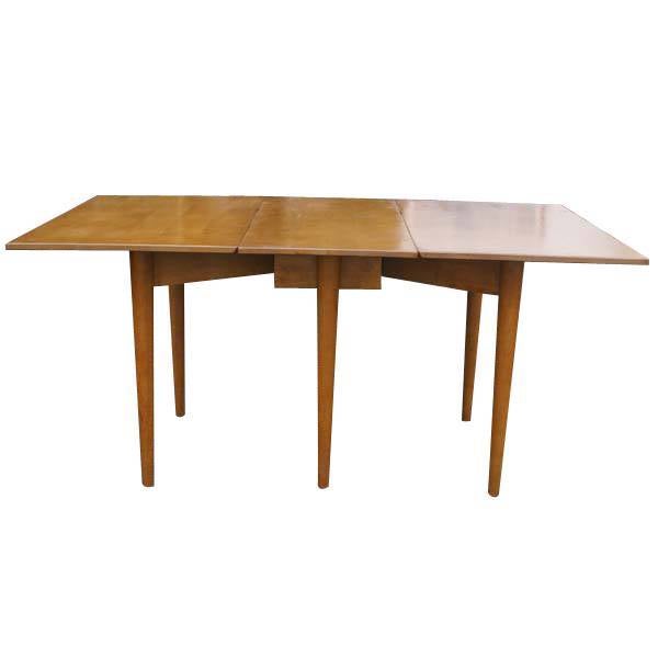 A mid century modern suite of dining furniture designed by Russel Wright and made by Conant Ball.  The set includes a birch drop leaf dining table that expands from 16.5