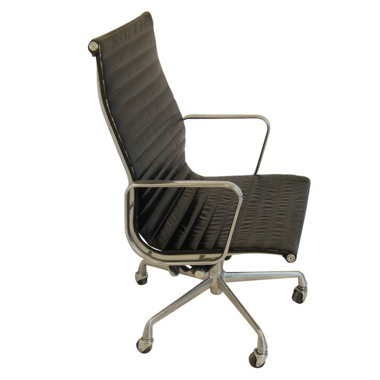 A mid century modern desk chair designed by Charles and Ray Eames and made by Herman Miller.  Part of the Aluminum Group series with a five-star aluminum base on casters with brown Edelman leather upholstery.  The chair tilts, swivels, and is height