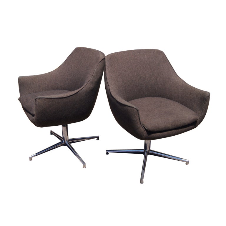 A pair of mid century modern lounge chairs made in Denmark.  Chrome bases with brown fabric upholstery.