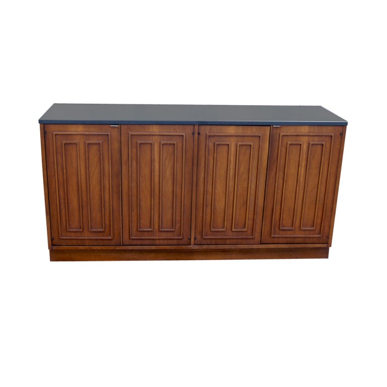 A mid century modern Sculptra series buffet or dresser made by Broyhill.  A walnut case with slate top.  Four doors concealing shelved storage and drawers.