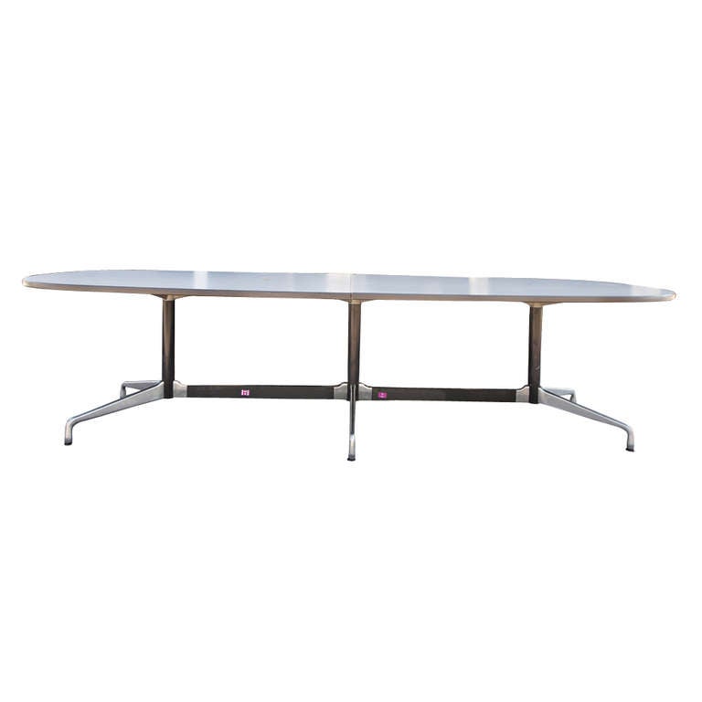 A mid century modern conference table designed by Charles and Ray Eames and made by Herman Miller.  A sleek grey laminate top and classic aluminum segmented base.  Could work as an over-sized modernist dining table or in any office as a conference
