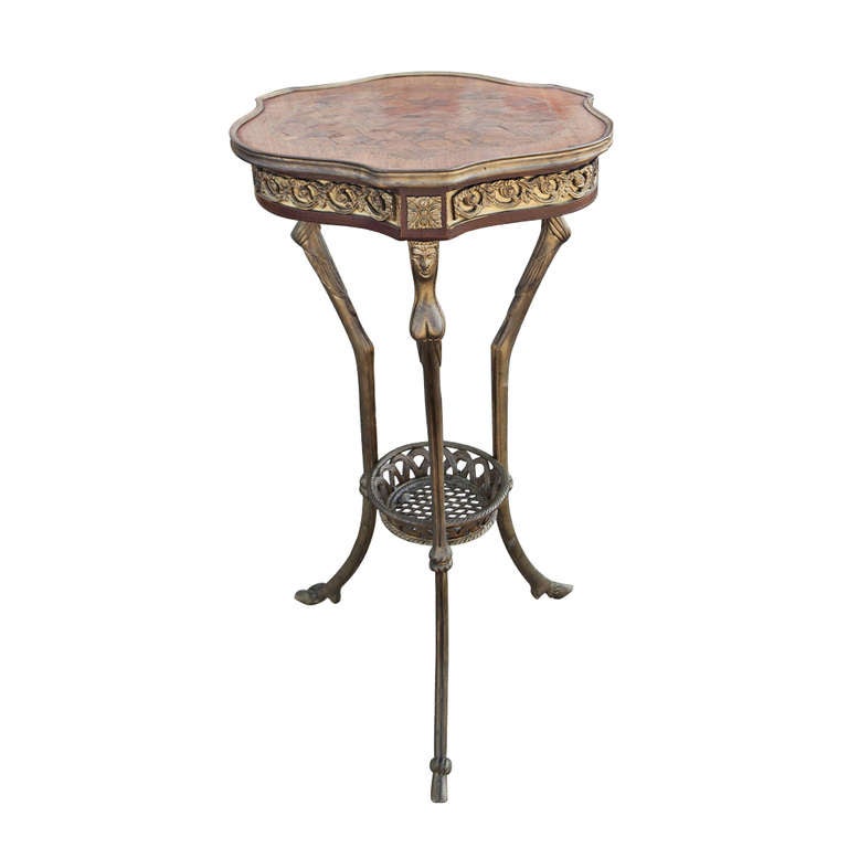 The tables each feature a trefoil parquetry top surrounded by a romanesque frieze, with female mask corbels atop three monopode legs joined by a circular shelf stretcher, terminating in hoofed feet.