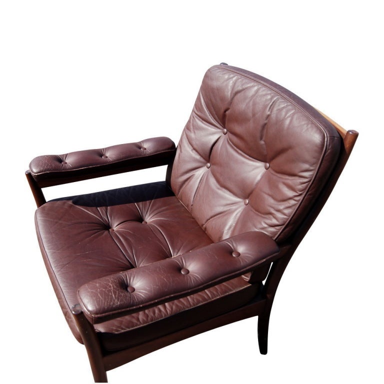 A mid century modern lounge chair made by G-Möbel in Sweden.  A walnut frame with brown leather button-tufted upholstery.
