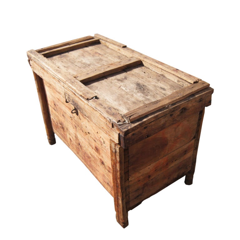 A rustic wooden trunk or chest made in Morocco perhaps at the turn of the twentieth century with carved feet, expsed nail heads and an iron latch.