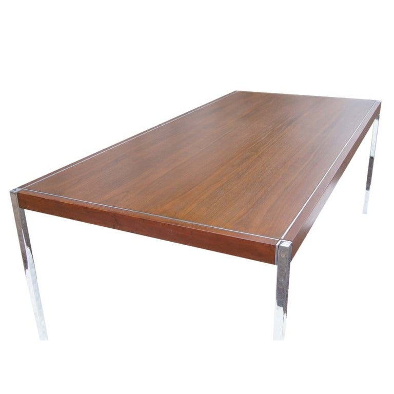 A mid century modern table designed by Richard Schultz and made by Knoll which could be used as a writing desk or as a dining table.  A walnut top with chrome legs and detailing.