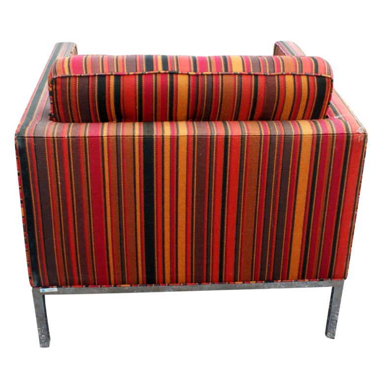 A mid-century lounge chair with Alexander Girard style striped upholstery and chrome base.