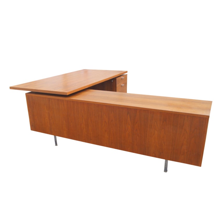 A mid century modern walnut desk with attached credenza designed by George Nelson and made by Herman Miller.  The credenza measures 81