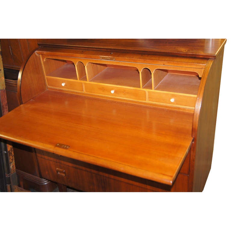 A Scandinavian Modern rosewood roll top cylinder desk. The fitted interior of teak with a pull out writing surface.  Three drawers with recessed rosewood pulls.