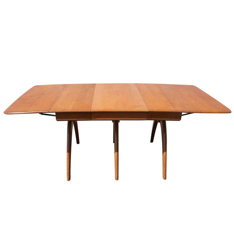 Most popular table by Heywood-Wakefield with butterfly supports for drop leaves. This top-of-the-line table is Heywood-Wakefield's longest table when fully opened. It has three boomerang legs, and wing-supported drop leaves make it an unparalleled