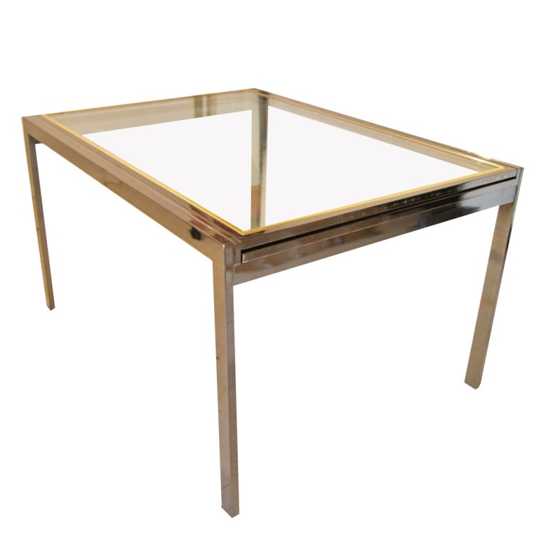 A mid century modern extension dining table designed by Milo Baughman and made by Thayer Coggin.  A chrome frame with decorative brass inserts around the glass tops.  The table expands from 42