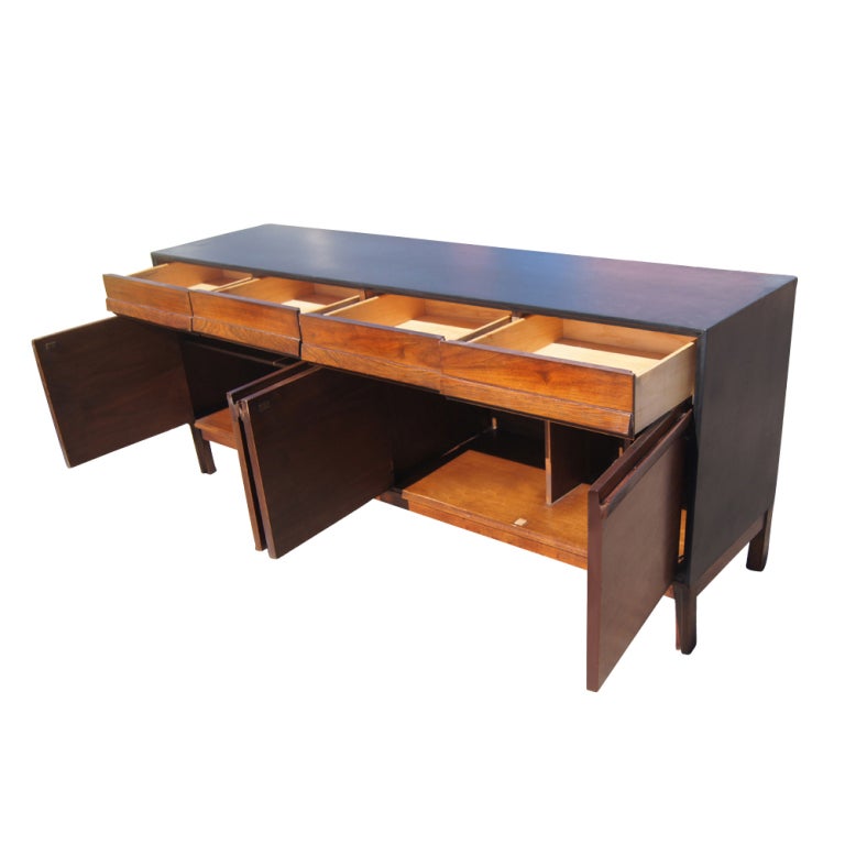 A mid century buffet or credenza made by American of Martinsville.  A walnut case with ebonized top and sides.  Two sets of double doors concealing storage and four drawers.