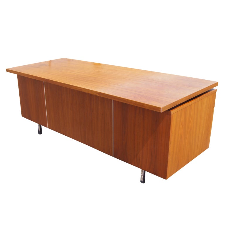 A mid century modern executive desk designed by George Nelson and made by Herman Miller.  Walnut with a floating top and chrome legs and pulls.