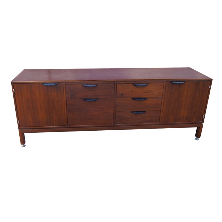 A mid century modern walnut credenza designed by Jens Risom and made by Jens Risom Design.  Five drawers and two doors with shelved storage.