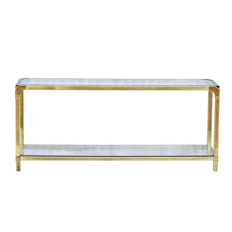 A beautiful and architectural brass and glass console table by Mastercraft. This is a very stylish and practical console in polished brass with glass top.