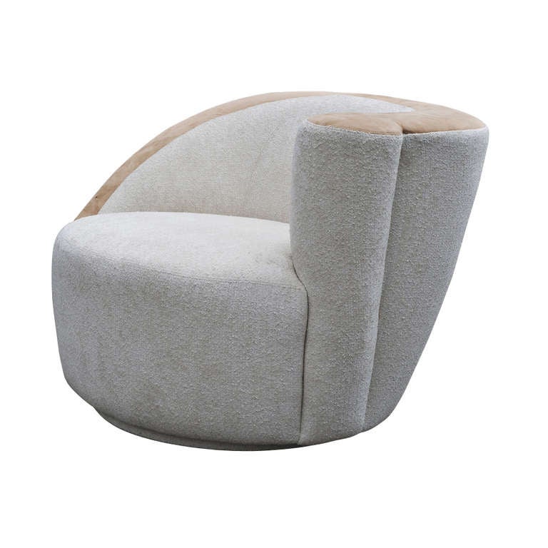 A Nautilus swivel lounge chair designed by Vladimir Kagan.  A fine expression of asymmetry in contemporary furniture design.  Upholstered in an off-white plush fabric with a contrasting tan top.