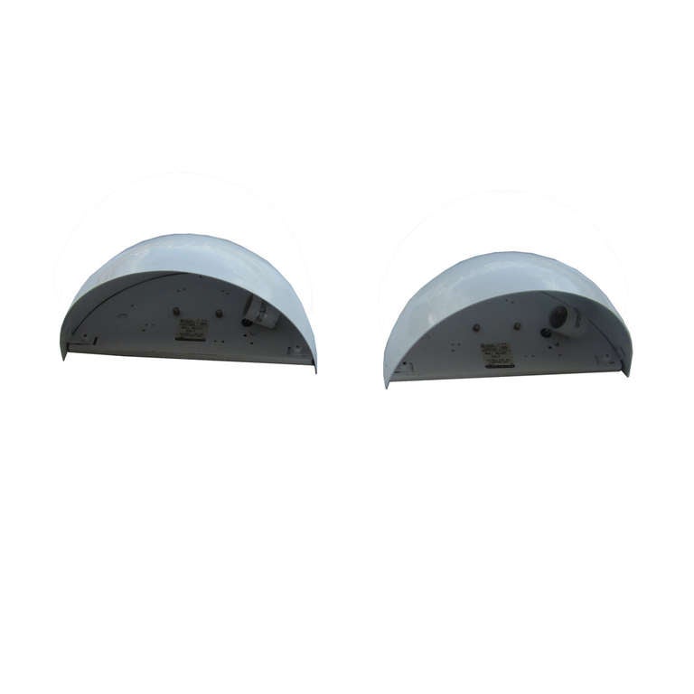 A pair of fine, half dome sconces with one light, made by Lightolier. The lamps are designed to be open at the top, providing upwards ambient lighting. A simple, classic design, reminiscent of the Art Deco style. 

Five pairs are available. Price