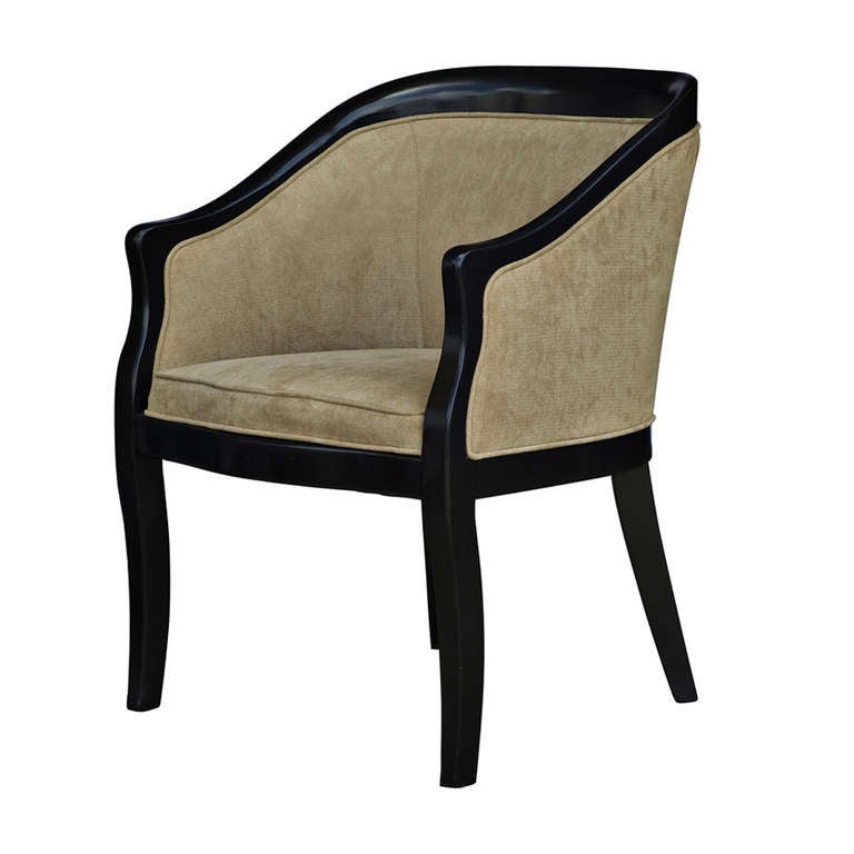 A pair of Hollywood Regency lounge or armchairs.  Gracefully curved pair of chairs with black lacquer frames and newly upholstered in a rich herringbone fabric.