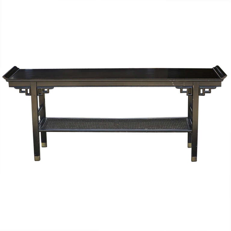 Preciosa consola lacada en negro de inspiración asiática a la manera de James Mont.  

El estante central tiene dos inserciones de caña.  Las patas son de latón.
Preciosa consola de laca negra estilo pagoda de inspiración asiática.