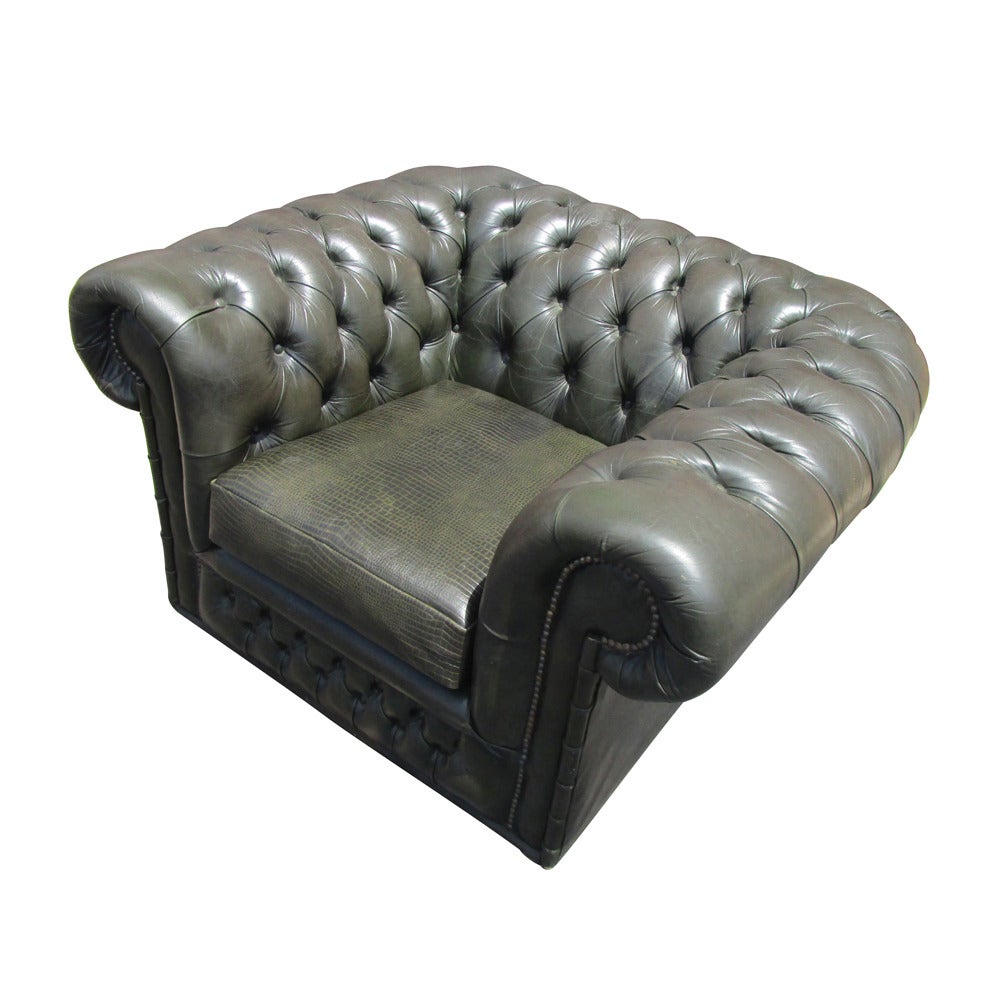 Green with brown undertones. Newly upholstered cushion in stamped reptile 
leather. 

Tufted with traditional rolled arms.