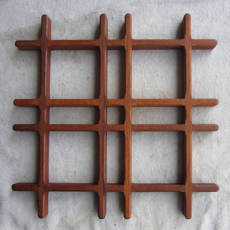 A pair of vintage Dansk teak trivets designed by Jens Quistgaard. These trivets have simple teak pieces rabbited together into shapes similar to pound signs or hashtags. Very early in the history of the collaboration between Jens H Quistgaard and