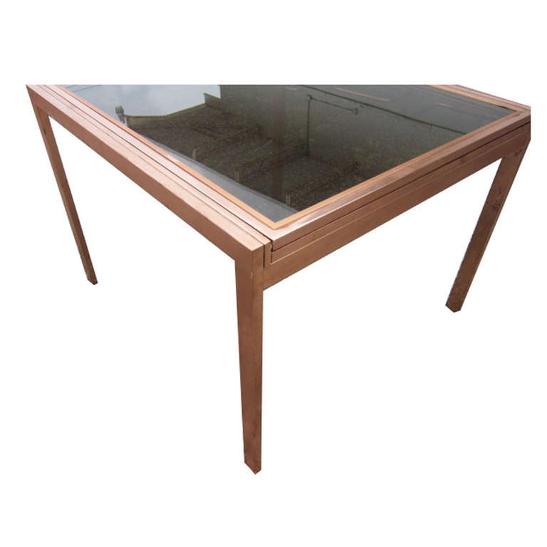 Vintage Milo Baughman Style Extension Dining Table

Circa 1970s

Rectangular copper & smoked glass dining table in the style of Milo Baughman

Glass top with copper lining

Made in USA

Age-appropriate patina