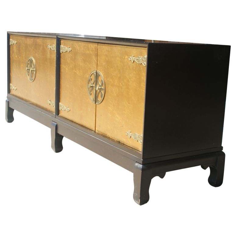 A double cabinet made by Johnson Furniture with the design attributed to Renzo Rutili. Two black lacquer cabinets with rich gold leaf doors and cast bronze hardware on a black lacquer base with Ming legs.