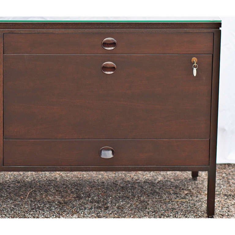 Elegantly crafted credenza made of walnut.  Credenza features distinctive half moon drawer and door pulls.