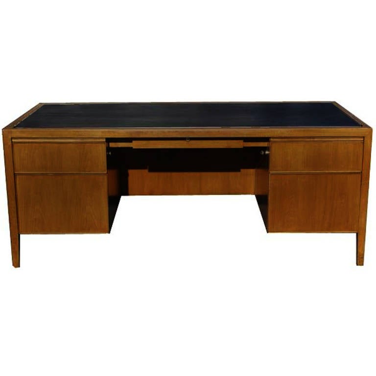 Features:

Walnut construction.
Black leather top.
Two file drawers.
Two standard size drawers.
Two writing tablets.
One center pencil drawer.
Chrome trim around the sides of the desk.