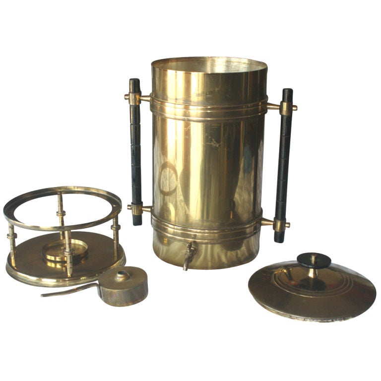 A mid century modern coffee urn designed by Tommi Parzinger and made by Dorlyn Silversmiths.  Brass with black segmented handles and a warming stand.