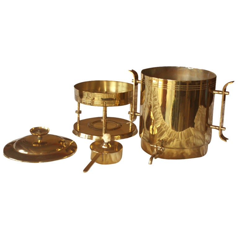 A Mid-Century Modern urn for coffee or hot water designed by Tommi Parzinger and made by Dorlyn Silversmiths. Brass with brass handles and a warming stand.