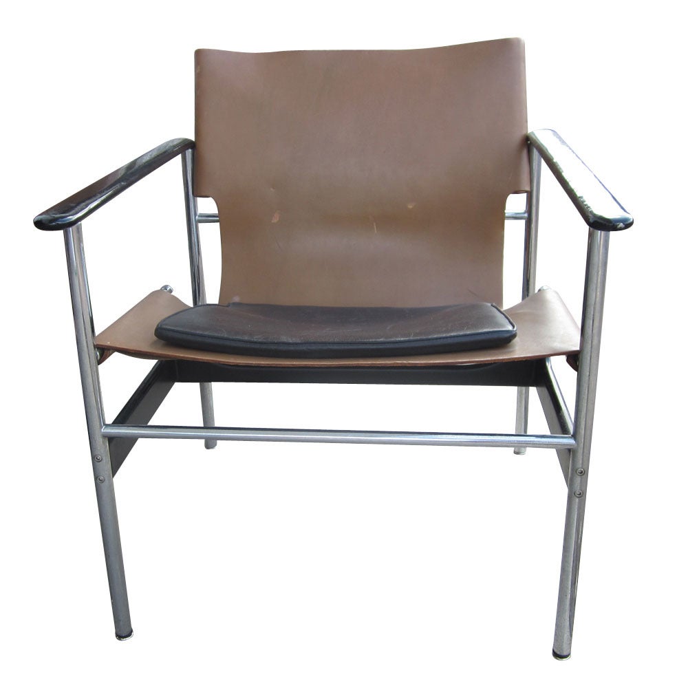 A pair of vintage Knoll Pollock lounge chairs model 657. These chairs have tubular steel construction; the armrests and struts are cast aluminum with black epoxy coating. The one-piece sling seatback is saddle leather, black.