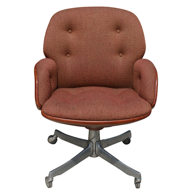 A pair of mid century modern task chairs made by Steelcase.  Burnt orange leather shell with an attached fabric seat and back cushion.  Four-star extruded aluminum base on casters.