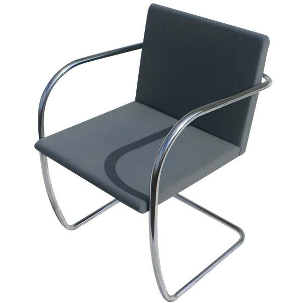 A mid century modern tubular Brno chair designed by Ludwig Mies van der Rohe and made by Knoll.  This is the rarer version with the thin pad seat and back.  A stainless steel frame upholstered in dark bluish gray fabric.  As shown in the last image,