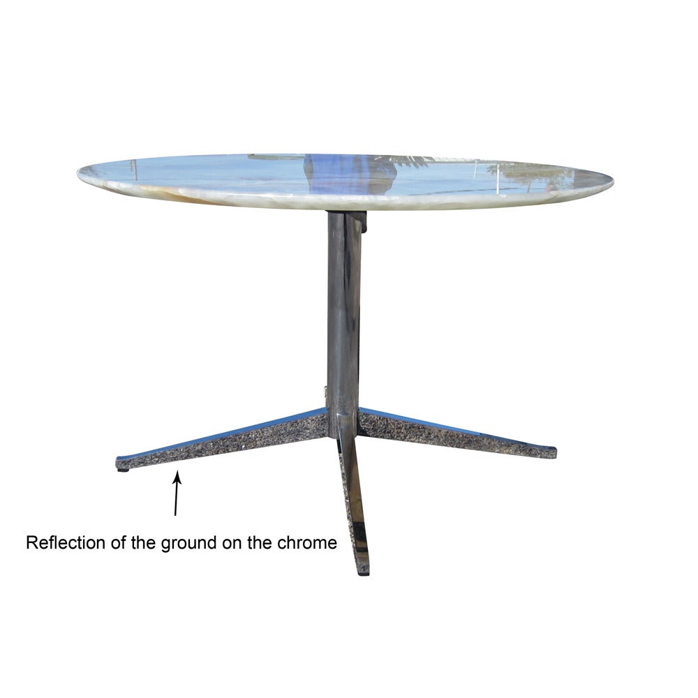 A vintage onyx round dining table in the style of Florence Knoll. Beautiful onyx top features lovely veining with strong white, red, and green coloring and textures with a chrome four star base. This classic design is enhanced by the attention to