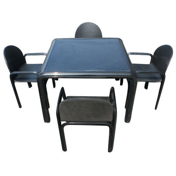 A mid century modern dining table and four chairs designed by Gae Aulenti and made by Knoll.  The table with a black rolled steel frame and black laminate top.  The chairs with black extruded aluminum frames and black leather upholstery.  The chairs
