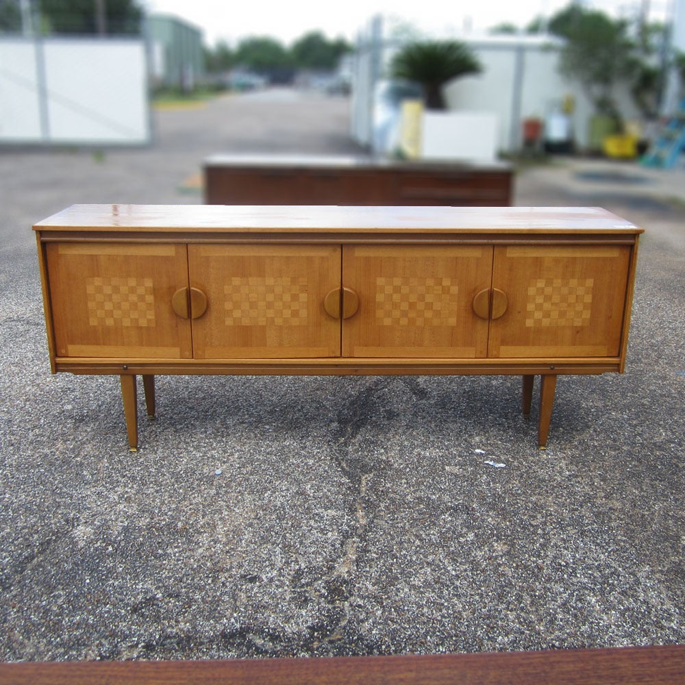 A vintage mid century credenza manufactured in the Mid-Century 1960s period. An incredibly well designed credenza with inlaid checkerboard parquetry. Beautiful slide panel doors and handles. This piece would be an excellent addition to any retro