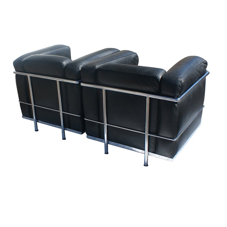 A pair of mid century modern Le Corbusier style Petite Confort club chairs made by Gordon International. Chrome frames with black leather cushions.