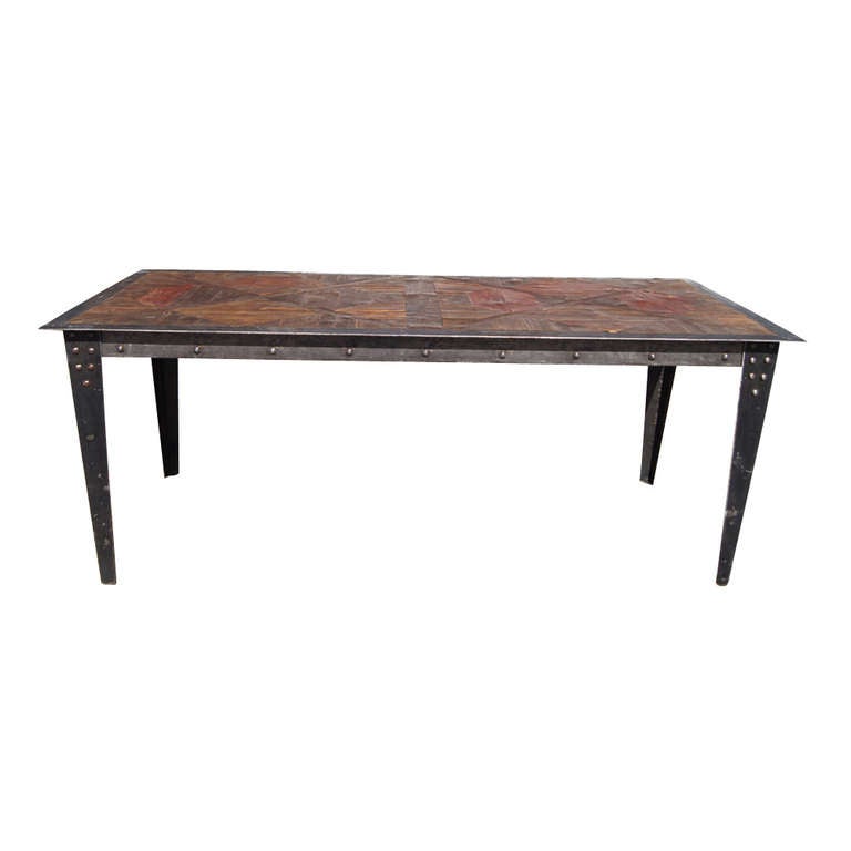 Industrial heavy steel frame with coating, stud details on legs. 
Top inlaid with various types of European woods.  Great patina on wood and steel.

 

Matching console table is w59