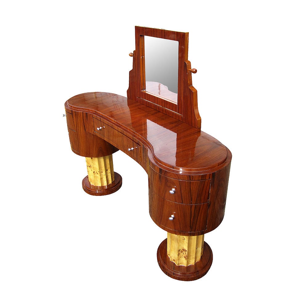 A double-pedestal, art deco vanity with five beautiful drawers, two on each side and a large one in the middle. Furnished with walnut wood and inset with steel pullouts, this piece sports an adjustable flip-mirror and a large, open top fit for