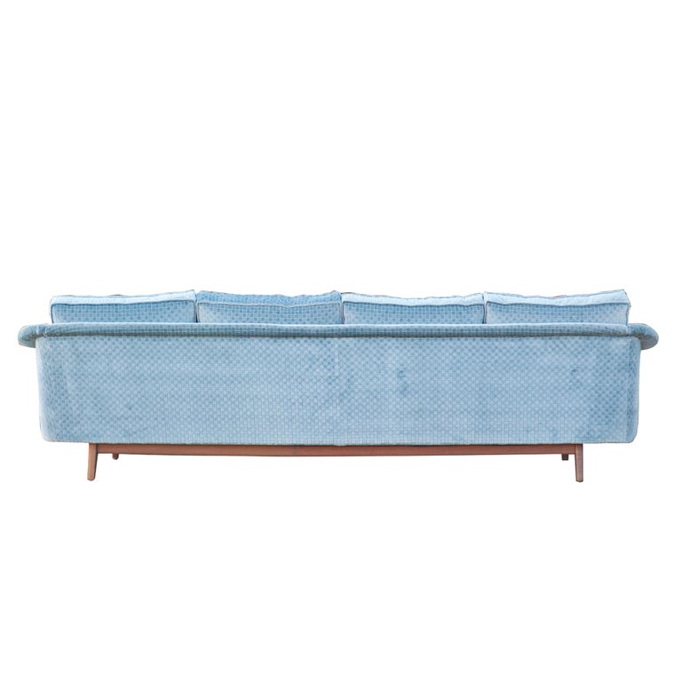 A long mid century modern sofa made by Dux.  A teak frame with original blue upholstery in a woven pattern.