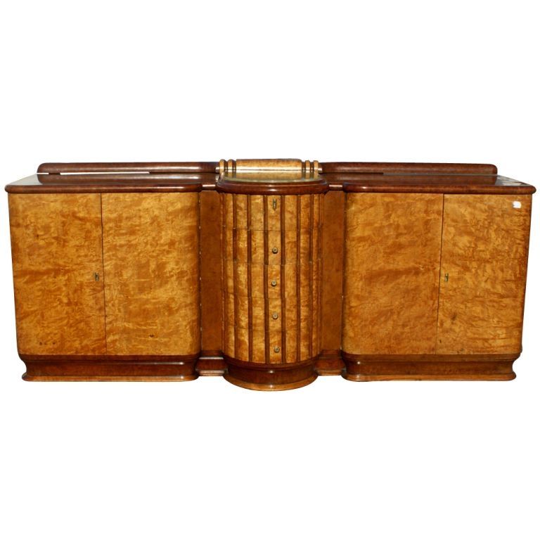 A large Art Deco buffet or sideboard, possibly of English origin, made from exotic burled wood.  Center section of five semi-circular drawers with fluted fronts and green onyx insert top.  Twin side compartments with double doors.  One side with