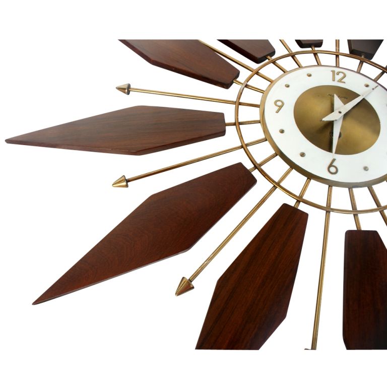 A mid century modern starburst wall clock made by Forestville.  Rosewood with brass and a winding mechanism.