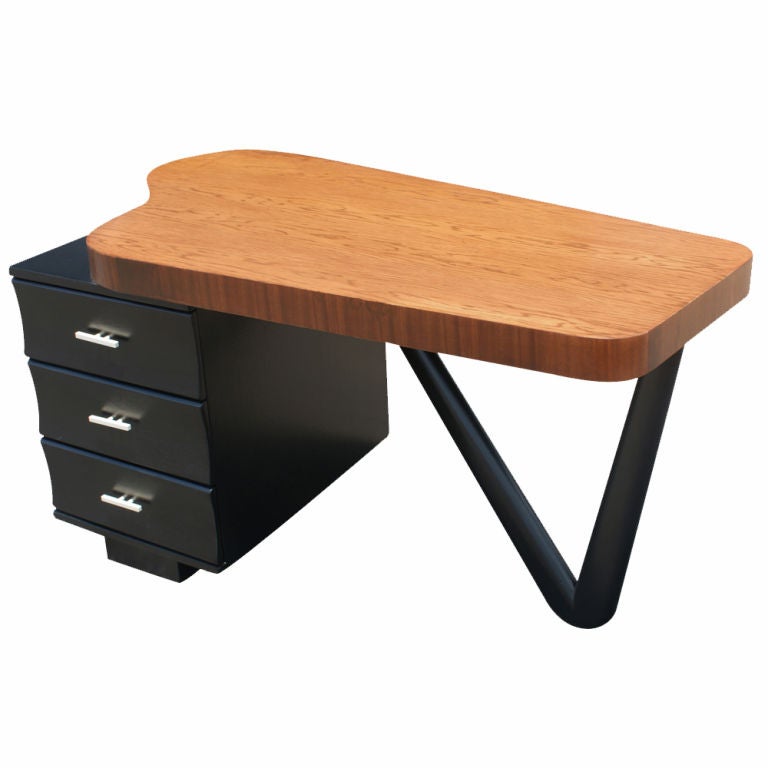 An Art Deco/mid century modern desk designed by Paul Frankl and made by Johnson Furniture.  Ebonized wood with a single pedestel with three drawers and V-shaped support.
